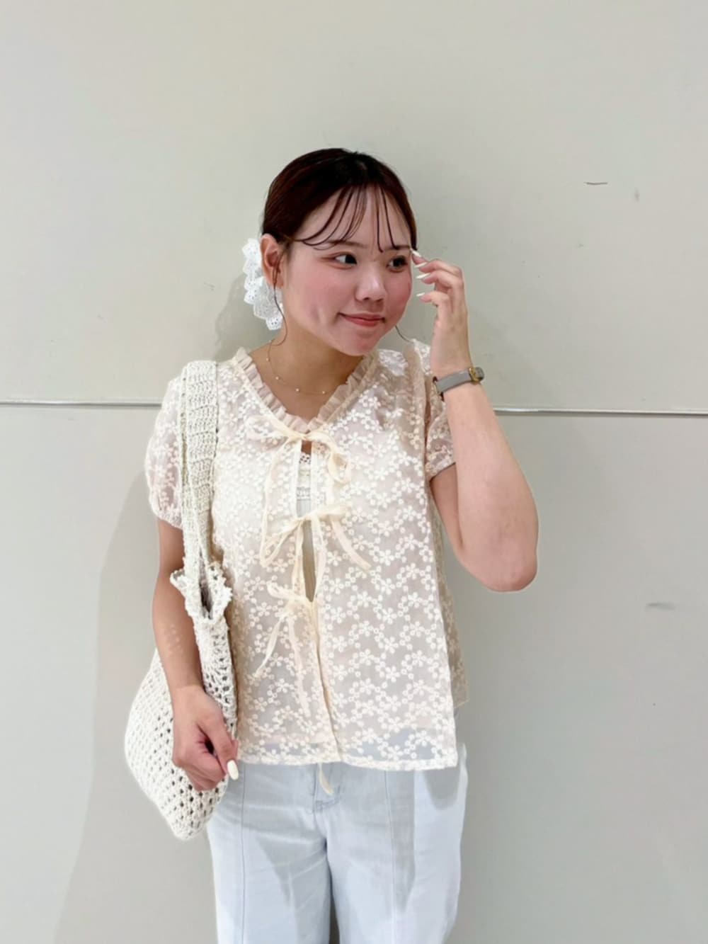 ホワイト系のトートバッグ、ブルー系のデニムパンツ、ホワイト系のシャツ/ブラウスを着用したレディースの夏コーディネートの2枚目の写真