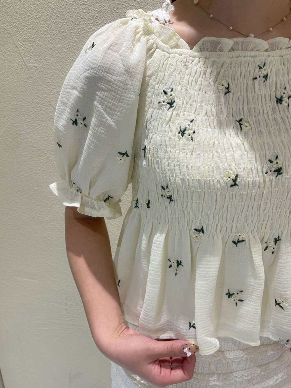 ホワイト系のショルダーバッグ、ホワイト系のスカート、イエロー系のシャツ/ブラウスを着用したレディースの夏コーディネートの3枚目の写真