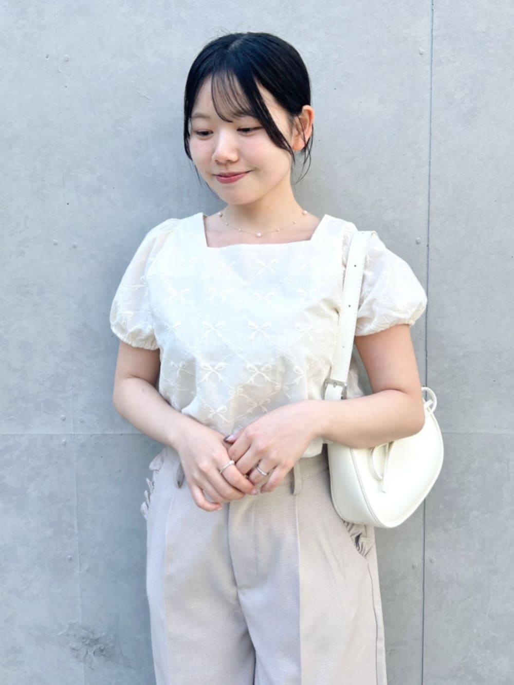 ベージュ系のその他パンツ、ホワイト系のショルダーバッグ、ホワイト系のシャツ/ブラウスを着用したレディースの春コーディネートの2枚目の写真