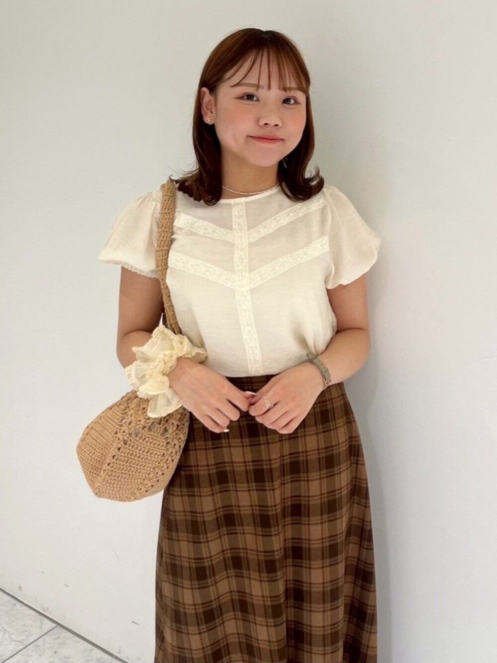 ブラウン系のショルダーバッグ、ホワイト系のシャツ/ブラウス、ブラウン系のスカートを着用したレディースの秋コーディネートの2枚目の写真