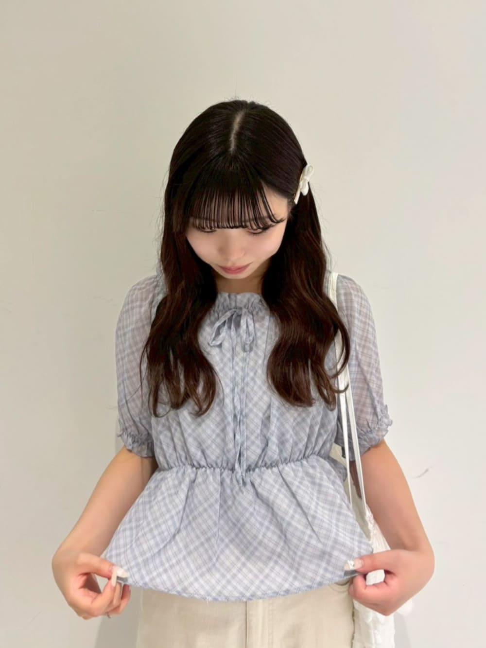 ホワイト系のトートバッグ、ホワイト系のデニムパンツ、ブルー系のシャツ/ブラウスを着用したレディースの夏コーディネートの2枚目の写真