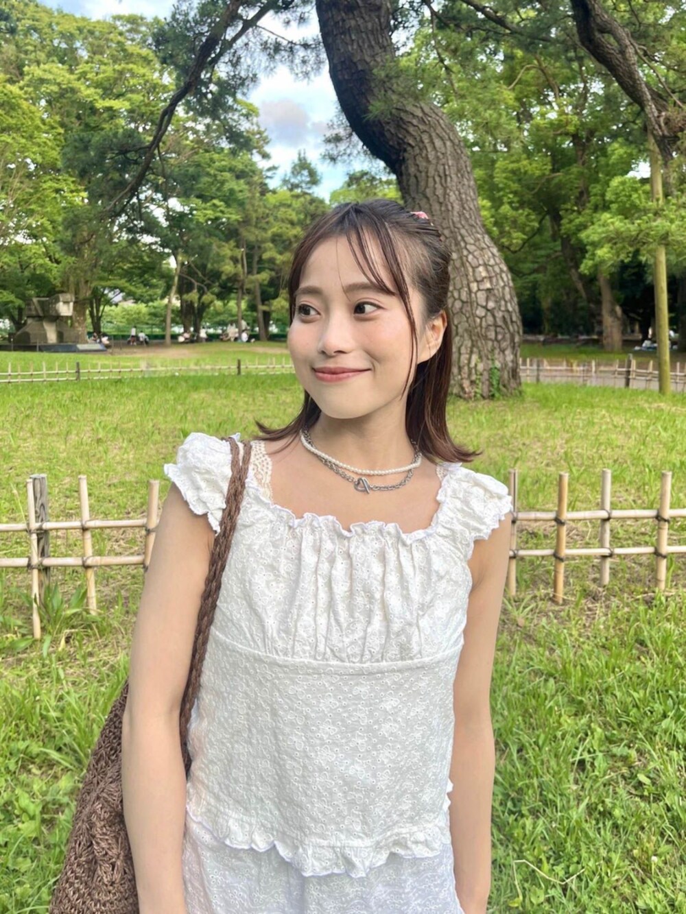 ホワイト系のシャツ/ブラウス、ブラウン系のトートバッグを着用したレディースの夏コーディネートの2枚目の写真