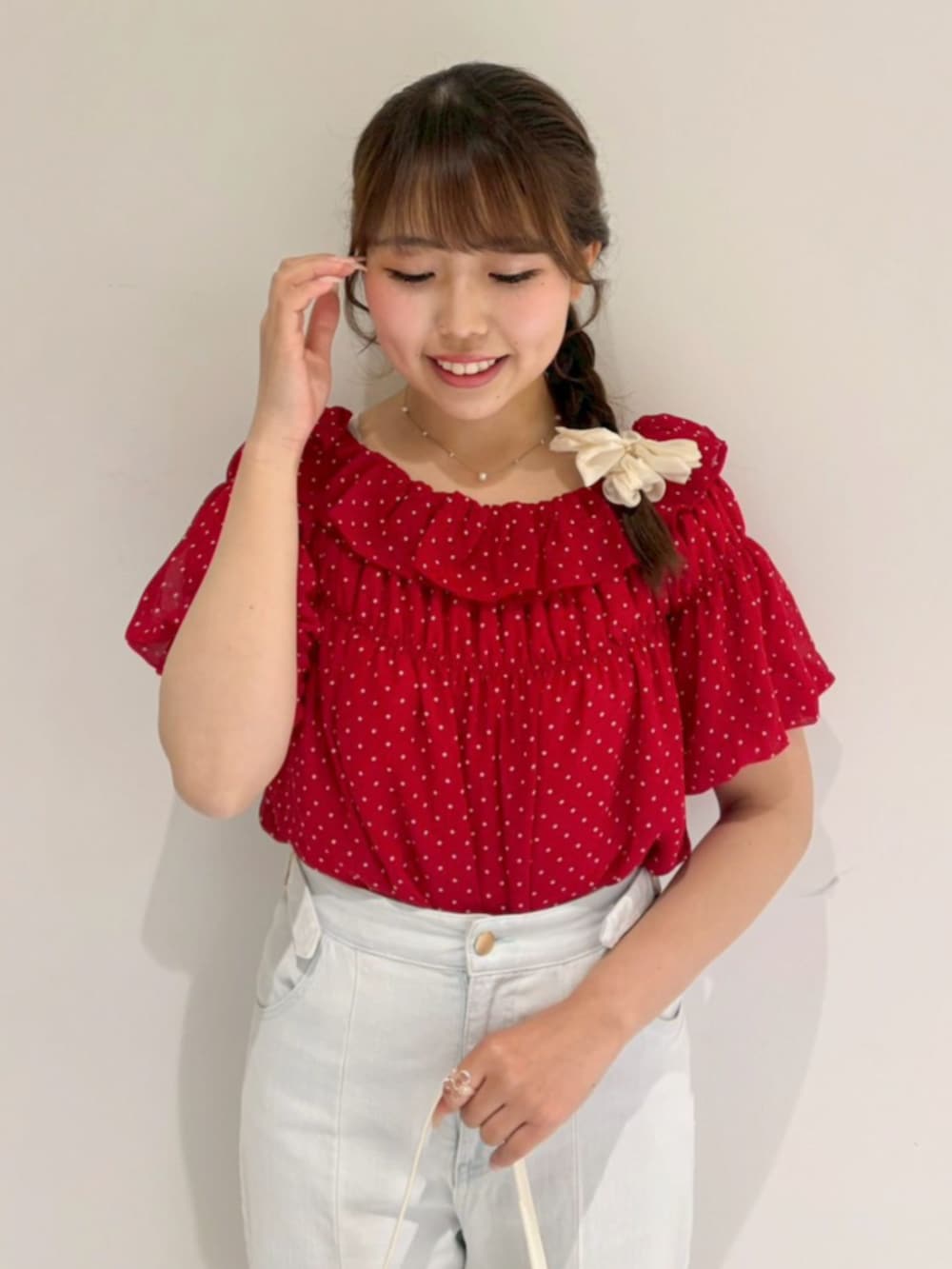 ホワイト系のショルダーバッグ、ブルー系のデニムパンツ、レッド系のシャツ/ブラウスを着用したレディースの夏コーディネートの2枚目の写真
