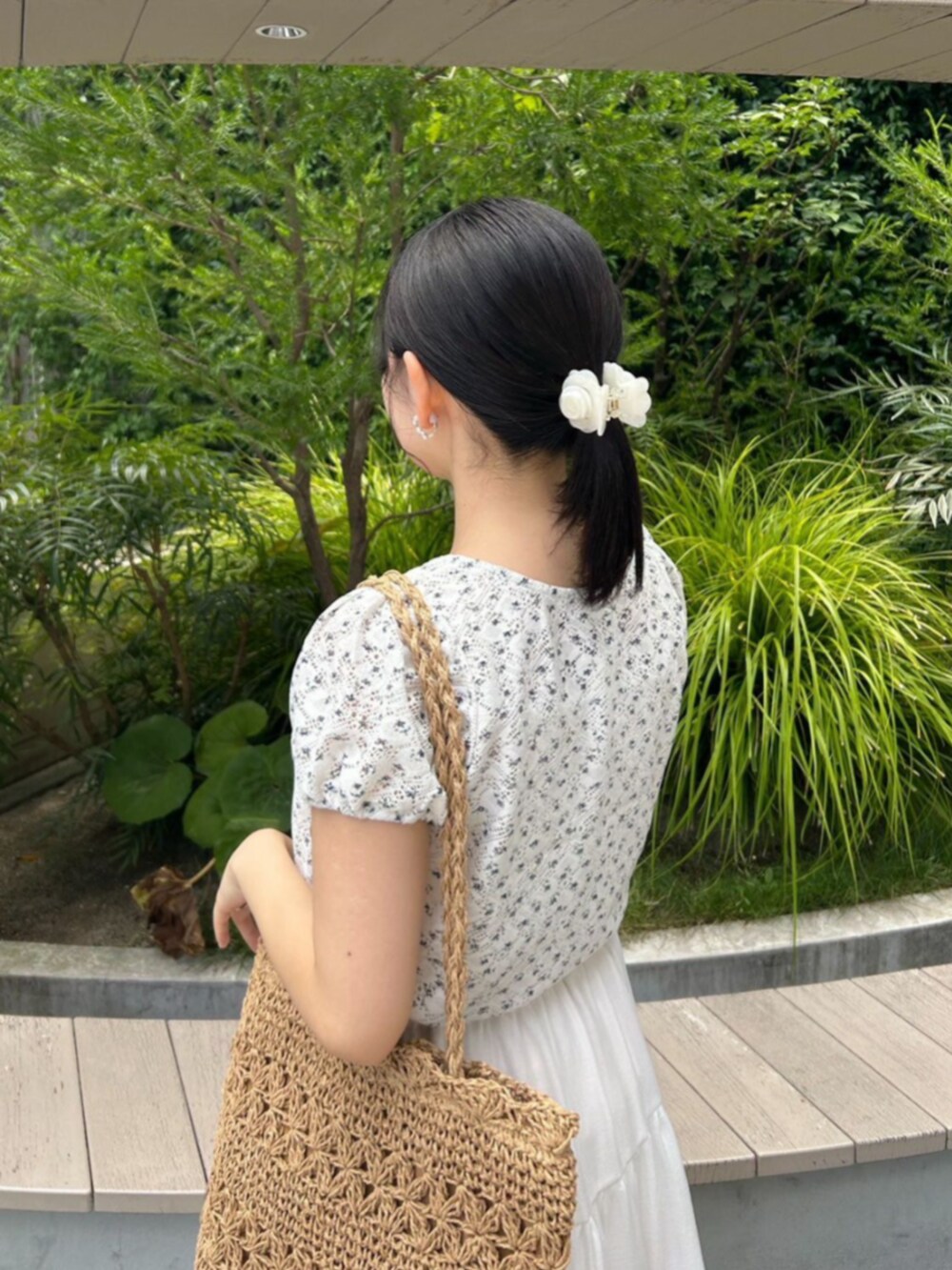 ブルー系のカーディガン/ボレロ、ホワイト系のスカート、ベージュ系のトートバッグを着用したレディースの夏コーディネートの2枚目の写真