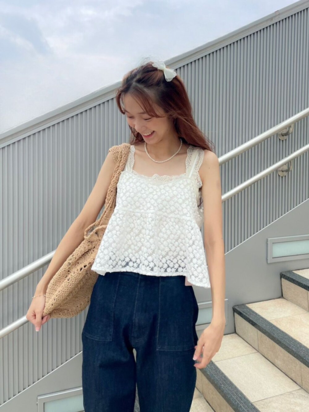 ホワイト系のキャミソール、ブルー系のその他パンツ、ブラウン系のショルダーバッグを着用したレディースの秋コーディネートの2枚目の写真