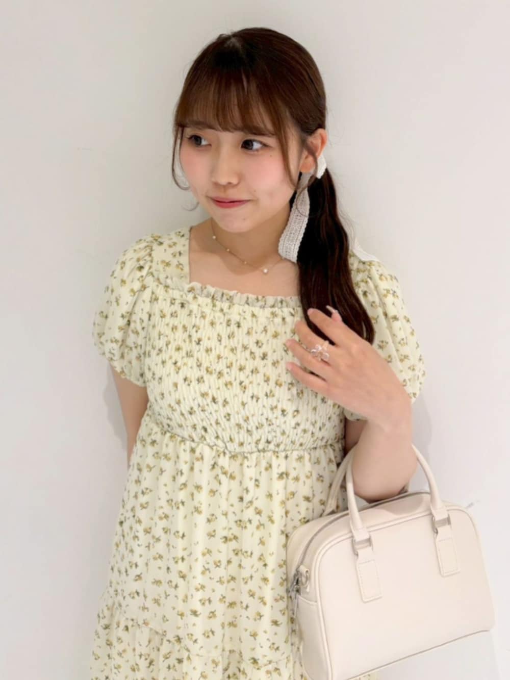 イエロー系のワンピースを着用したレディースの夏コーディネートの2枚目の写真
