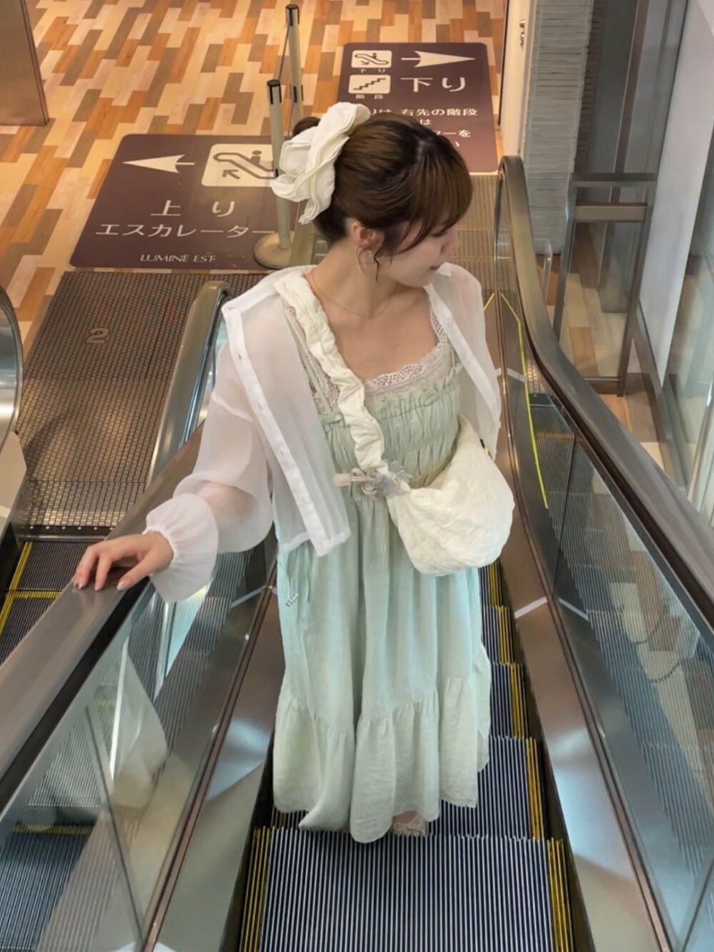 ホワイト系のキャミソール、ホワイト系のショルダーバッグ、グリーン系のワンピースを着用したレディースの夏コーディネートの2枚目の写真