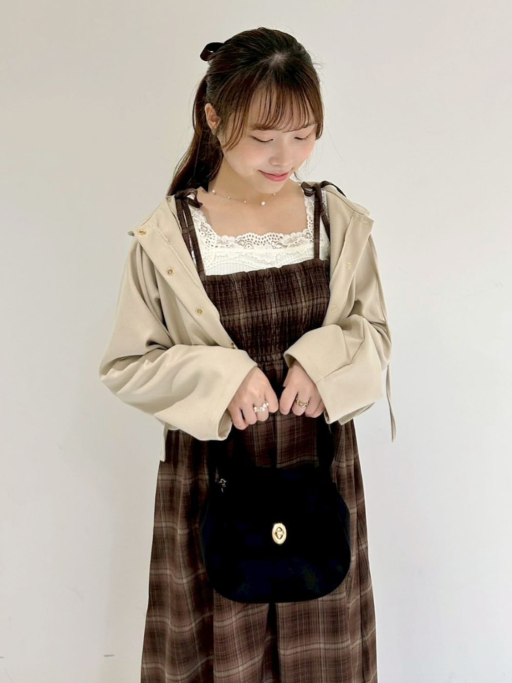 ブラック系のショルダーバッグ、ホワイト系のブルゾン、ブラウン系のワンピースを着用したレディースの秋コーディネートの2枚目の写真