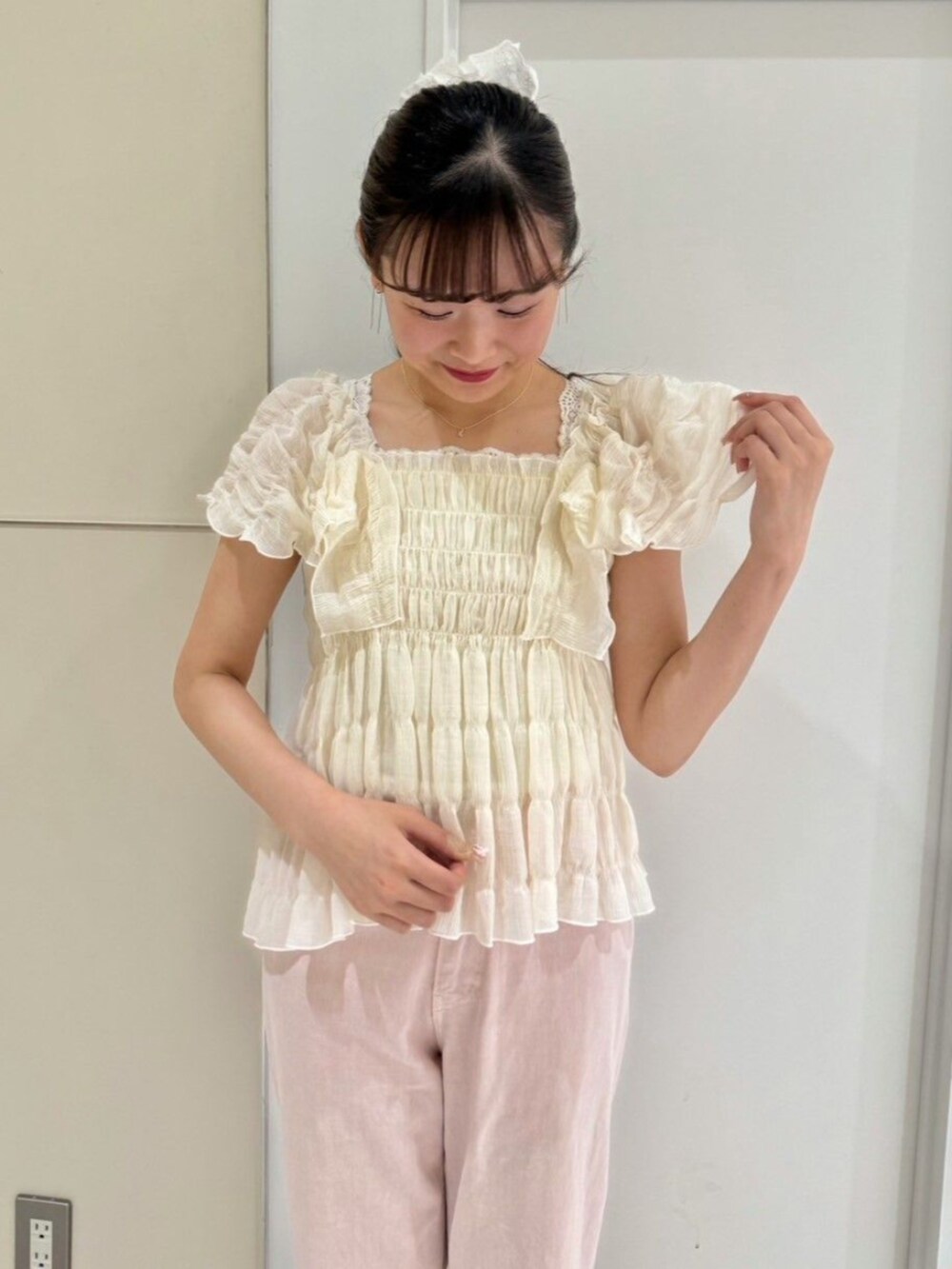 ピンク系のデニムパンツ、ホワイト系のシャツ/ブラウス、グレー系のショルダーバッグを着用したレディースの夏コーディネートの2枚目の写真