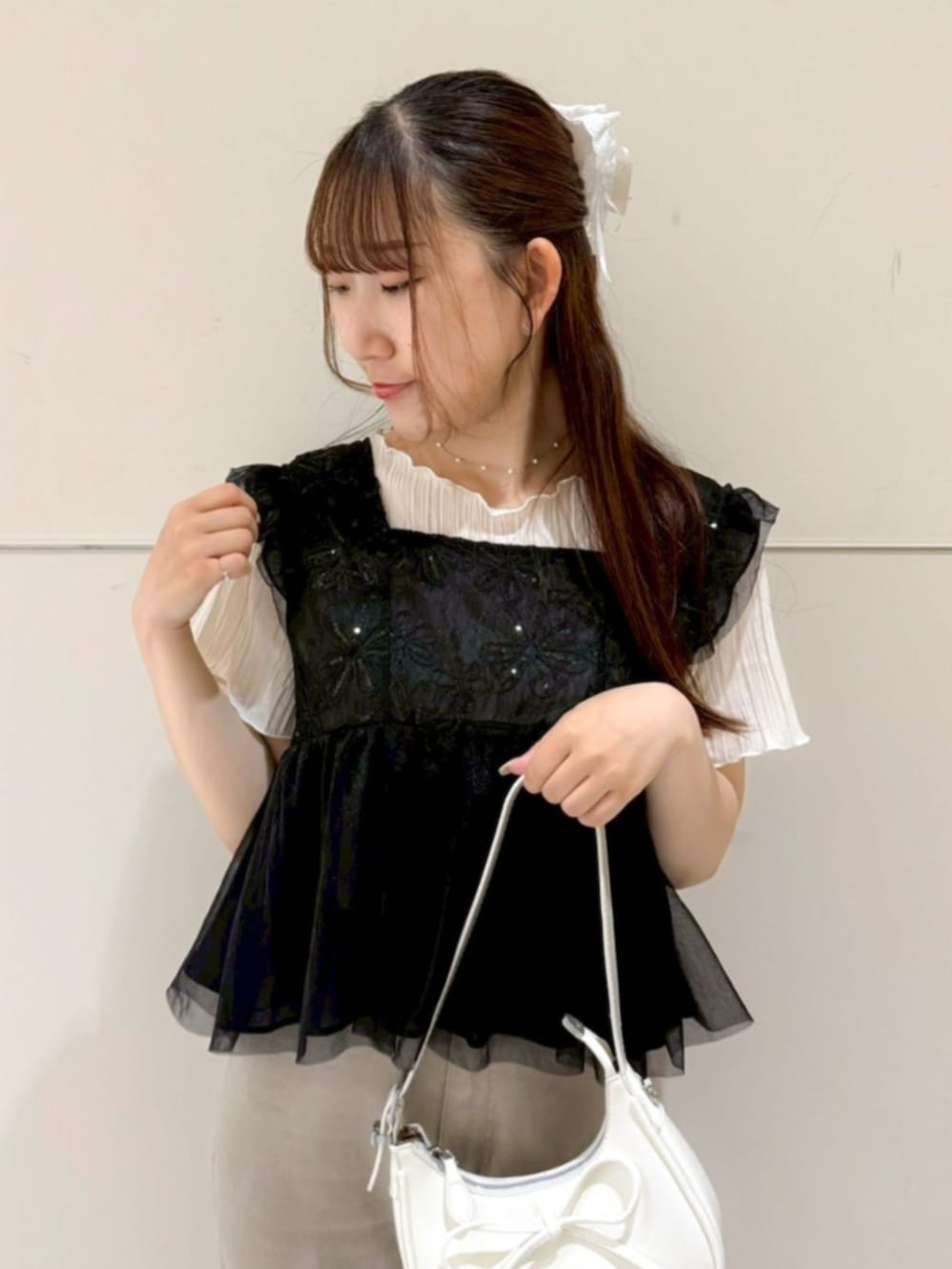 ホワイト系のTシャツ/カットソー、ブラック系のシャツ/ブラウス、ホワイト系のショルダーバッグを着用したレディースの夏コーディネートの2枚目の写真