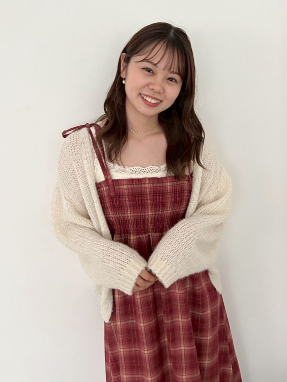 ホワイト系のカーディガン/ボレロ、レッド系のワンピース、ホワイト系のブーツを着用したレディースの秋コーディネートの3枚目の写真