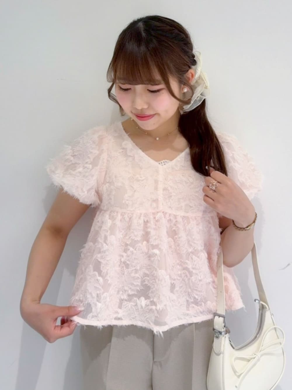 ベージュ系のその他パンツ、ホワイト系のショルダーバッグ、ピンク系のシャツ/ブラウスを着用したレディースの春コーディネートの2枚目の写真