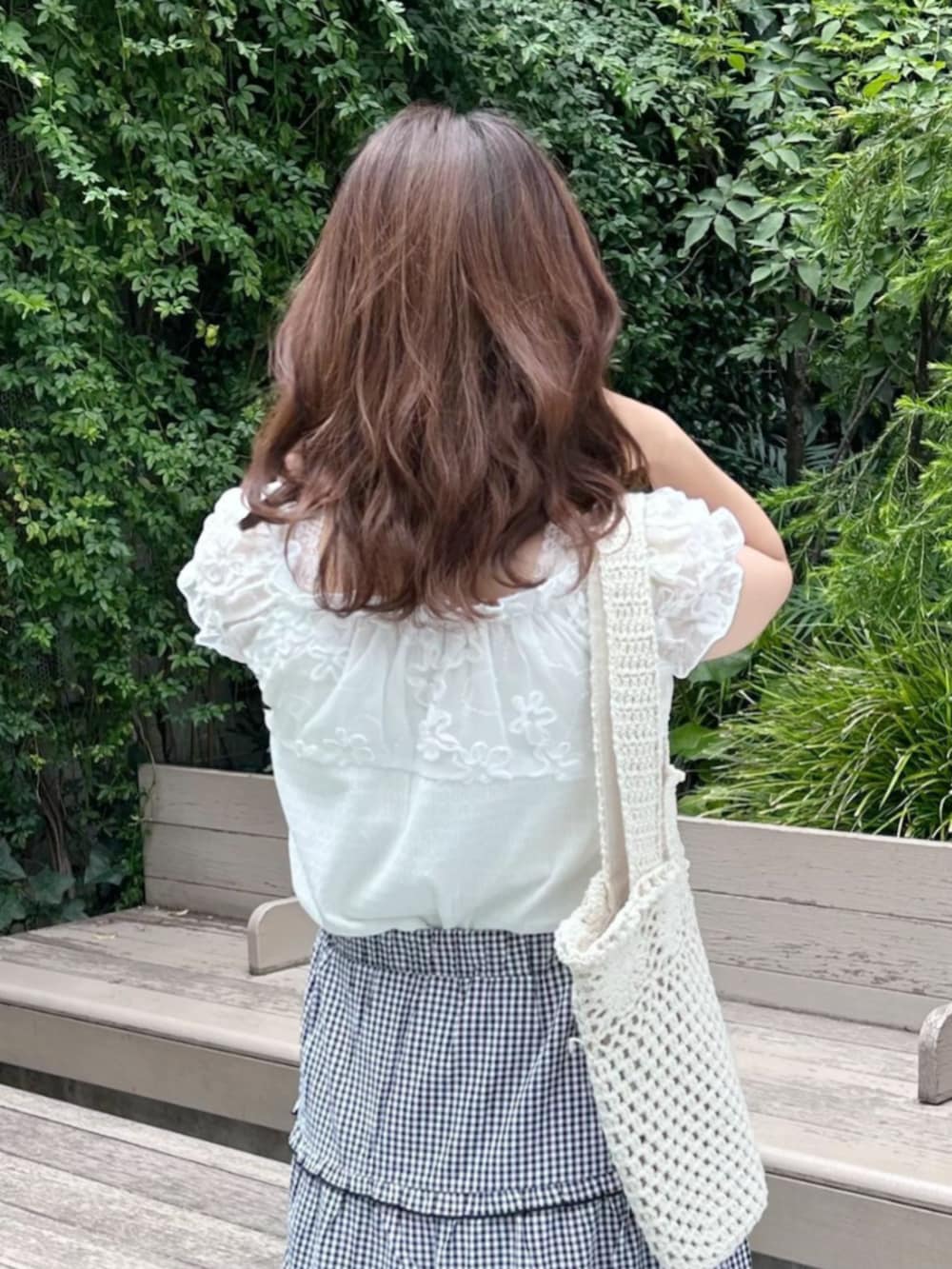 ブラック系のスカート、ホワイト系のトートバッグ、ホワイト系のシャツ/ブラウスを着用したレディースの夏コーディネートの2枚目の写真