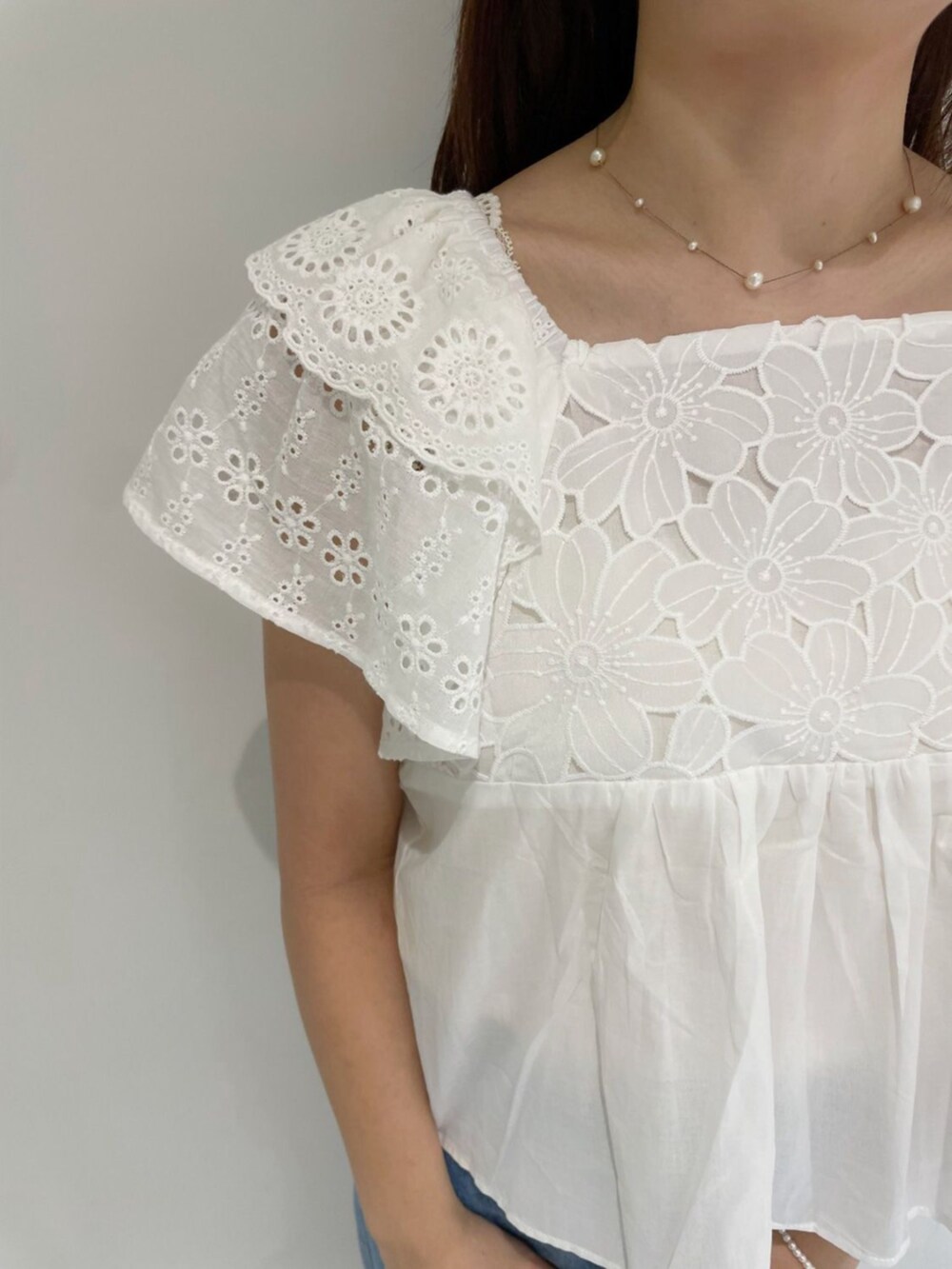 ブルー系のデニムパンツ、ホワイト系のシャツ/ブラウス、ブラウン系のショルダーバッグを着用したレディースの夏コーディネートの3枚目の写真