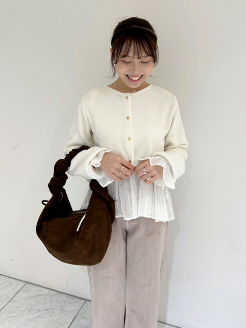 ホワイト系のカーディガン/ボレロ、ホワイト系のシャツ/ブラウス、ベージュ系のデニムパンツを着用したレディースの秋コーディネートの2枚目の写真