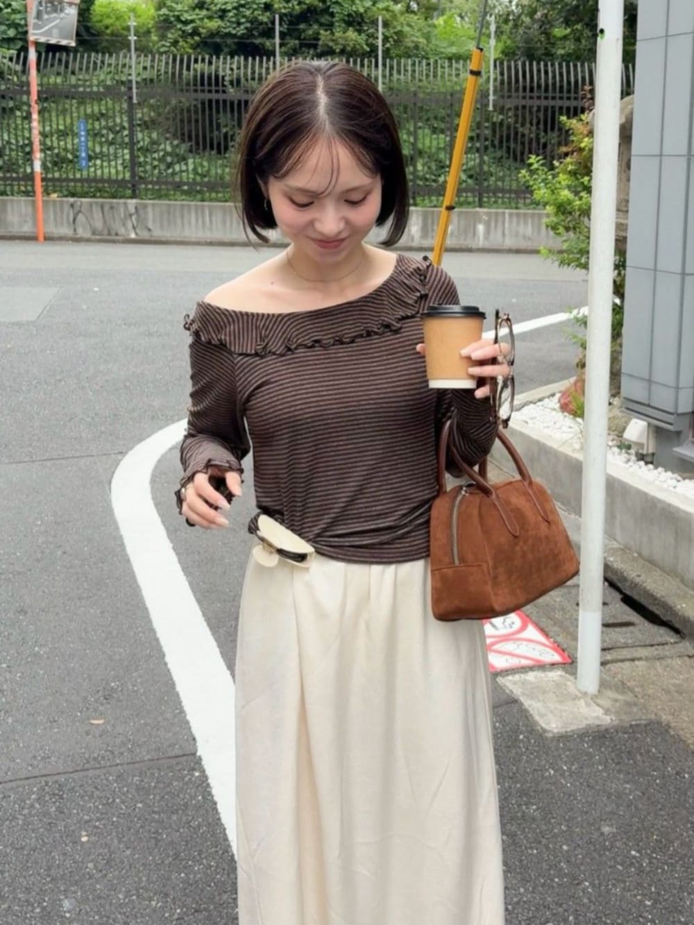 ホワイト系のスカート、ブラウン系のTシャツ/カットソー、ブラウン系のブーツを着用したレディースの夏コーディネートの2枚目の写真