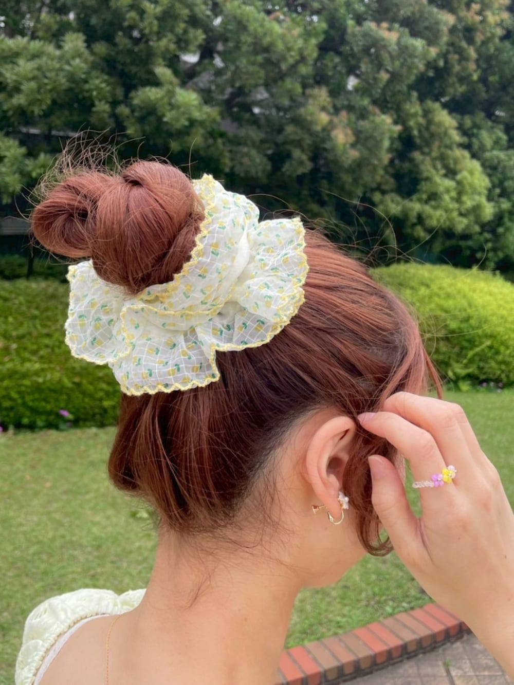 ブルー系のデニムパンツ、ブラウン系のショルダーバッグ、イエロー系のシャツ/ブラウスを着用したレディースの夏コーディネートの3枚目の写真