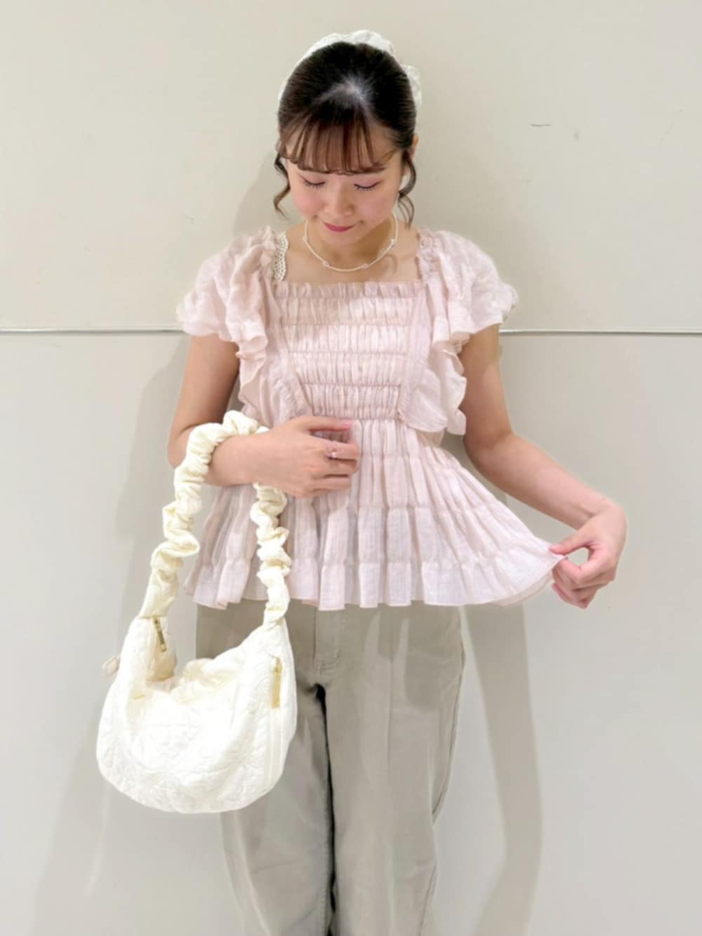 ホワイト系のショルダーバッグ、ピンク系のシャツ/ブラウス、ベージュ系のデニムパンツを着用したレディースの夏コーディネートの2枚目の写真