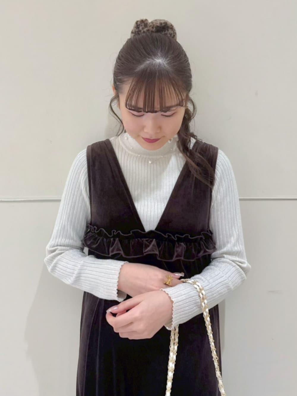 ホワイト系のニット/セーター、ホワイト系のショルダーバッグ、ブラウン系のワンピースを着用したレディースの冬コーディネートの2枚目の写真