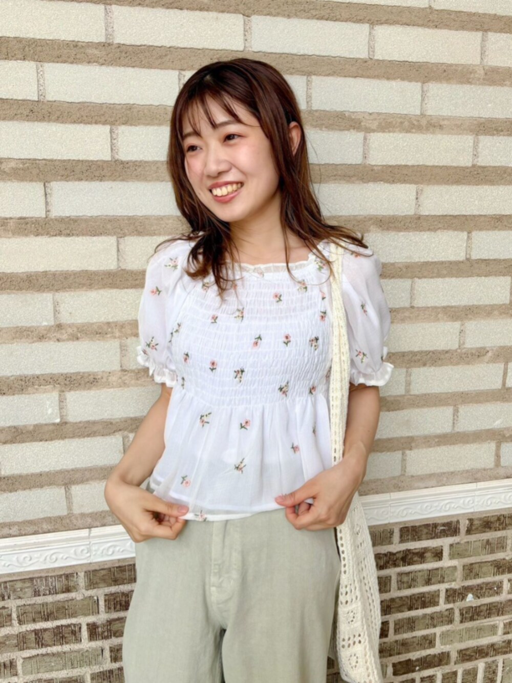 ホワイト系のシャツ/ブラウス、ホワイト系のかごバッグ、グリーン系のデニムパンツを着用したレディースの夏コーディネートの2枚目の写真