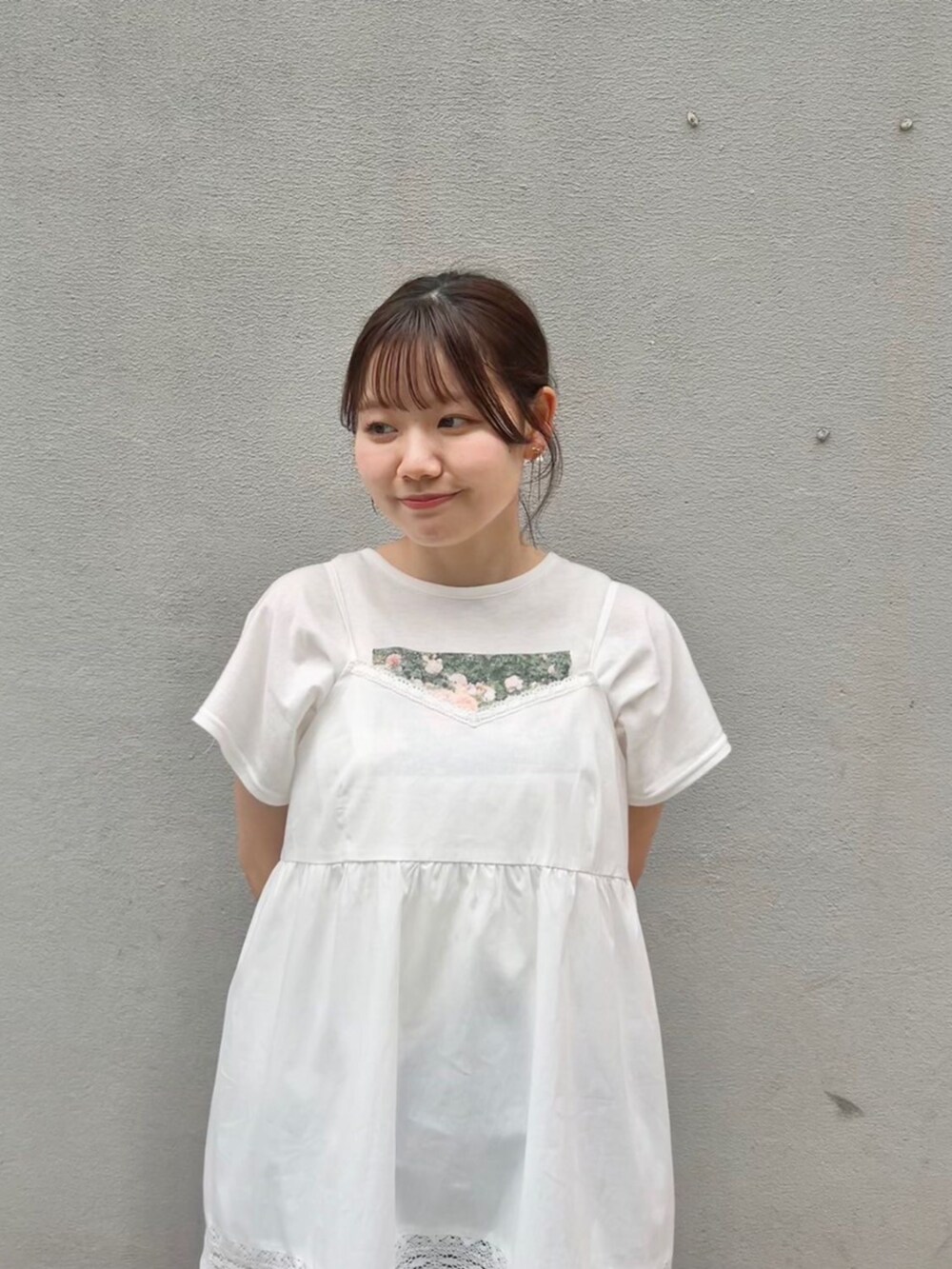 ブルー系のデニムパンツ、ホワイト系のワンピース、ピンク系のTシャツ/カットソーを着用したレディースの春コーディネートの2枚目の写真
