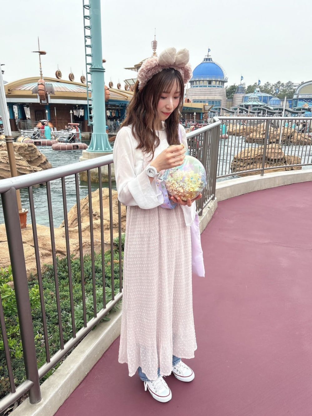 ブルー系のテーラードジャケット、ホワイト系のワンピースを着用したレディースの春コーディネートの2枚目の写真