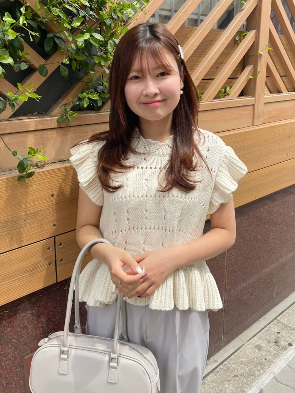 グレー系のその他パンツ、ホワイト系のニット/セーター、グレー系のショルダーバッグを着用したレディースの春コーディネートの2枚目の写真