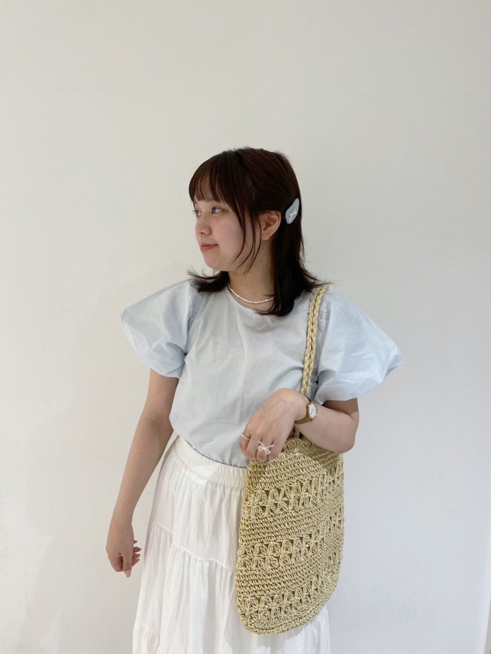 ホワイト系のスカート、ブルー系のシャツ/ブラウス、ベージュ系のトートバッグを着用したレディースの春コーディネートの2枚目の写真
