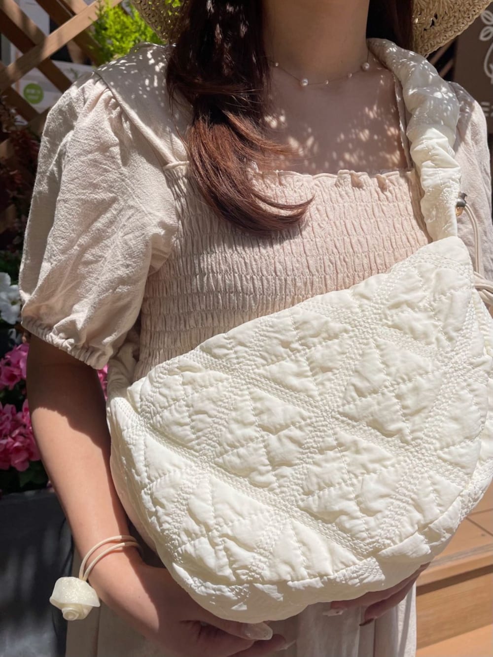 ホワイト系のショルダーバッグ、ホワイト系のワンピース、ゴールド系のネックレスを着用したレディースの春コーディネートの3枚目の写真