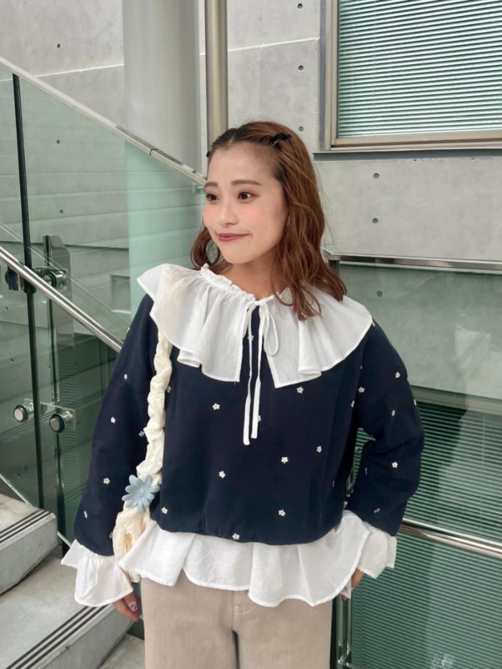 ホワイト系のショルダーバッグ、ベージュ系のデニムパンツ、ホワイト系のシャツ/ブラウスを着用したレディースの秋コーディネートの2枚目の写真