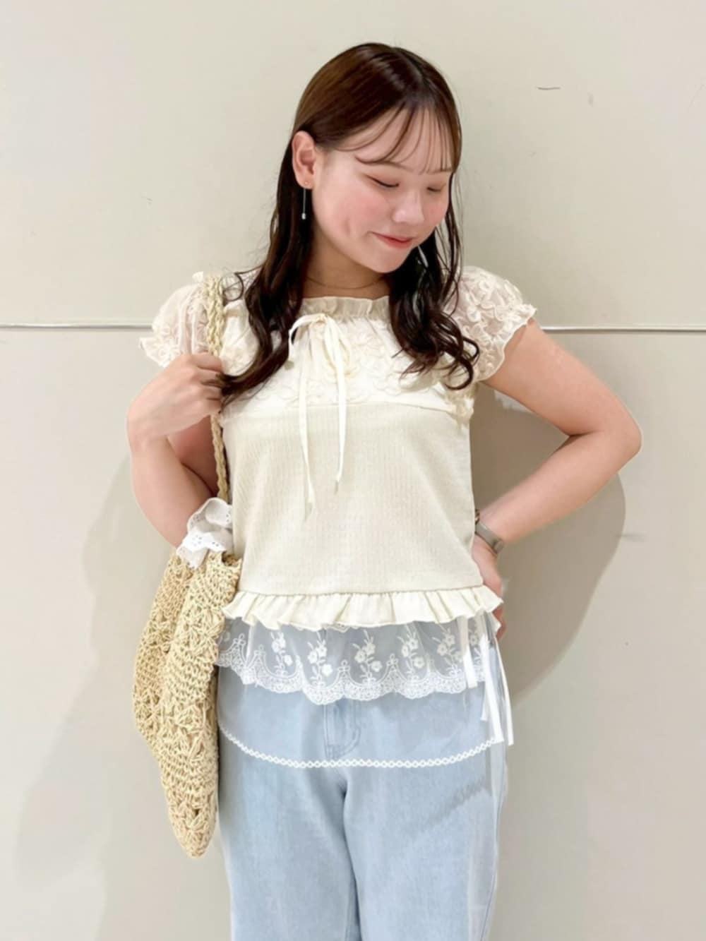 ホワイト系のかごバッグ、ブルー系のデニムパンツ、ホワイト系のスカートを着用したレディースの夏コーディネートの2枚目の写真