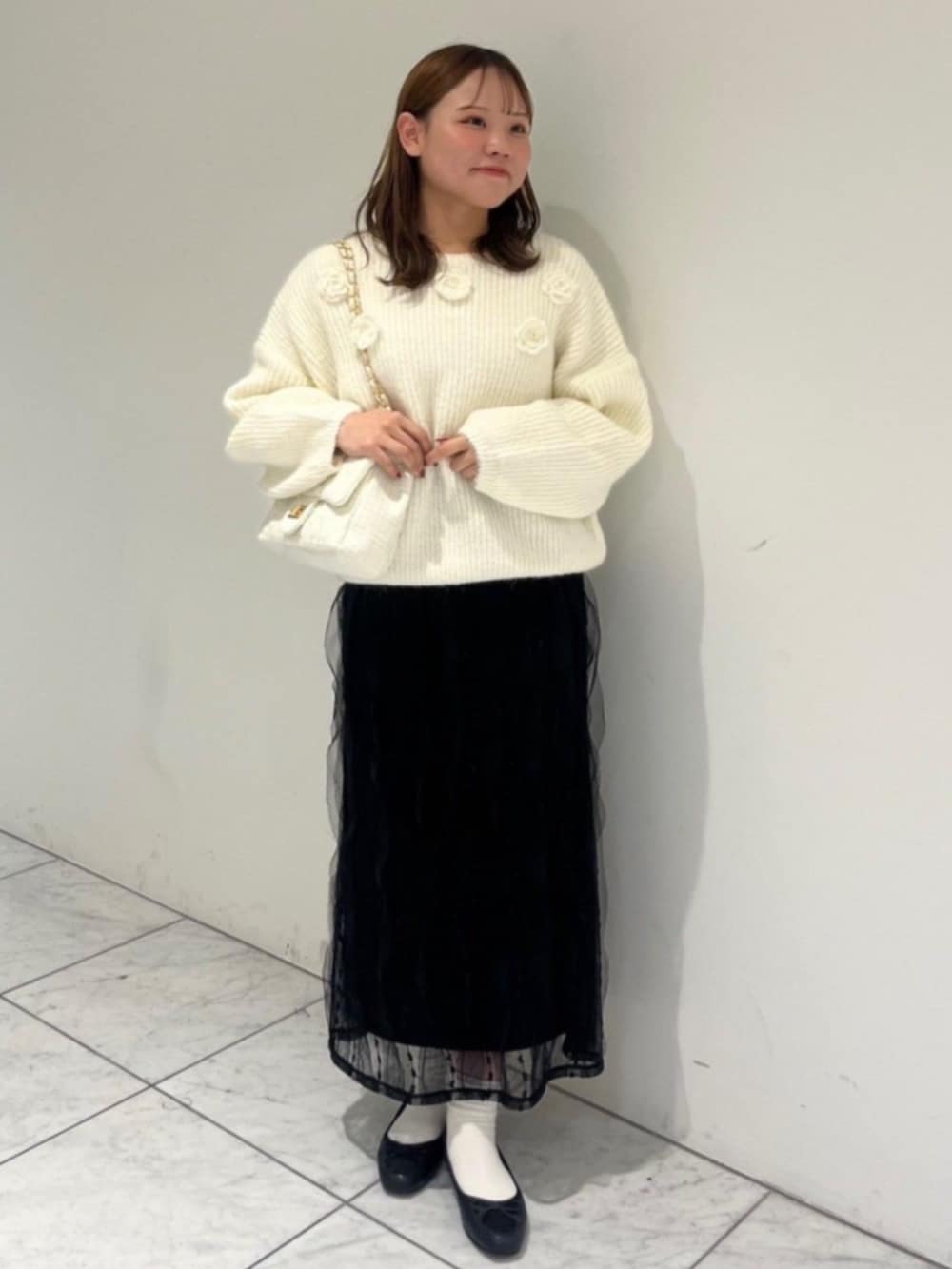 ホワイト系のショルダーバッグ、ブラック系のスカート、ホワイト系のムートンコートを着用したレディースの秋コーディネートの5枚目の写真