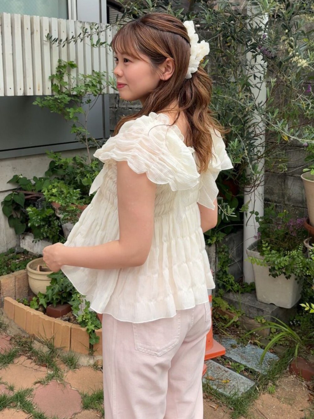 ピンク系のデニムパンツ、ホワイト系のシャツ/ブラウス、ホワイト系のバレッタ/ヘアクリップを着用したレディースの春コーディネートの2枚目の写真