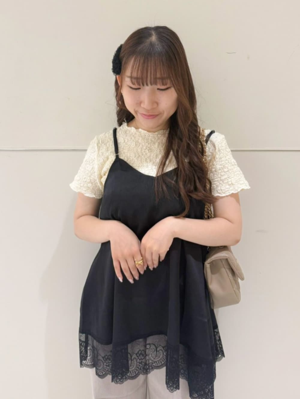 ベージュ系のショルダーバッグ、ホワイト系のTシャツ/カットソー、ブラック系のキャミソールを着用したレディースの夏コーディネートの2枚目の写真