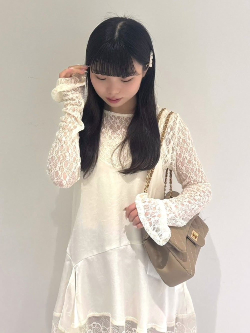 ベージュ系のショルダーバッグ、ホワイト系のTシャツ/カットソー、ピンク系のデニムパンツを着用したレディースの夏コーディネートの2枚目の写真