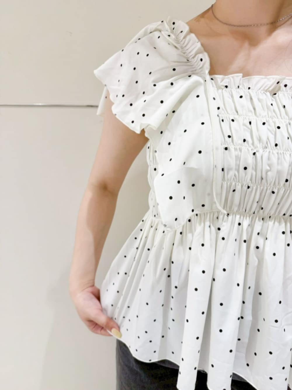 ブラック系のデニムパンツ、ブルー系のショルダーバッグ、ホワイト系のシャツ/ブラウスを着用したレディースの夏コーディネートの3枚目の写真