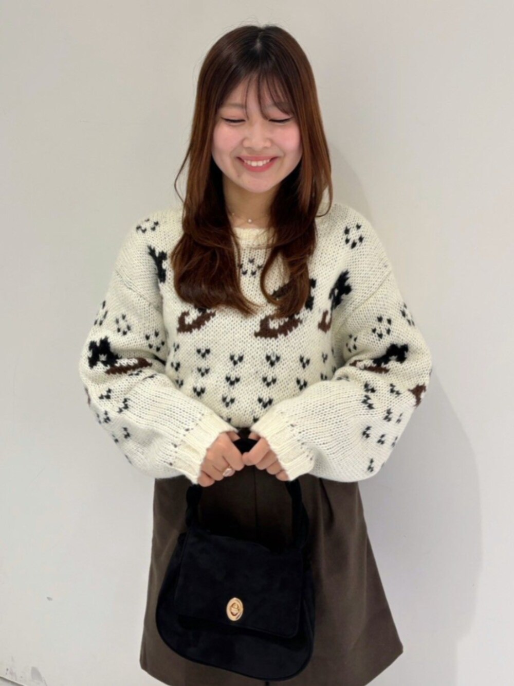 ブラック系のショルダーバッグ、ブラウン系のその他パンツ、ホワイト系のニット/セーターを着用したレディースの冬コーディネートの2枚目の写真