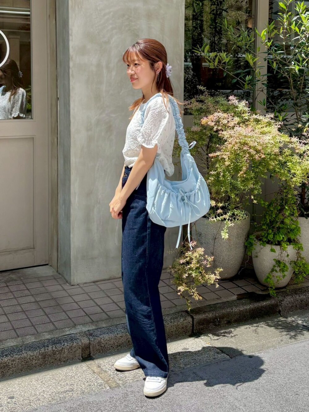 ブルー系のショルダーバッグ、パープル系のシャツ/ブラウス、ブルー系のデニムパンツを着用したレディースの夏コーディネートの2枚目の写真