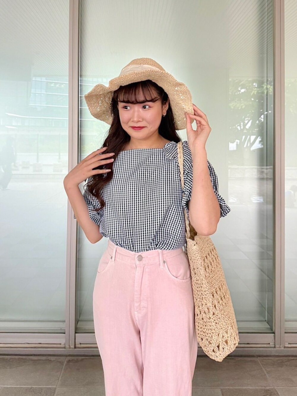 ブルー系のシャツ/ブラウス、ベージュ系のトートバッグ、ピンク系のデニムパンツを着用したレディースの春コーディネートの2枚目の写真