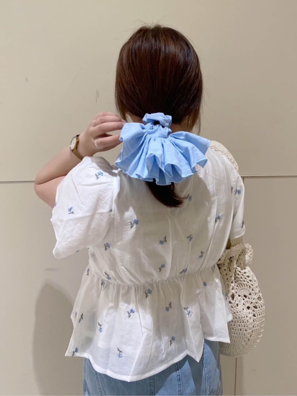 ホワイト系のシャツ/ブラウス、ホワイト系のショルダーバッグ、ブルー系のシュシュを着用したレディースの夏コーディネートの2枚目の写真