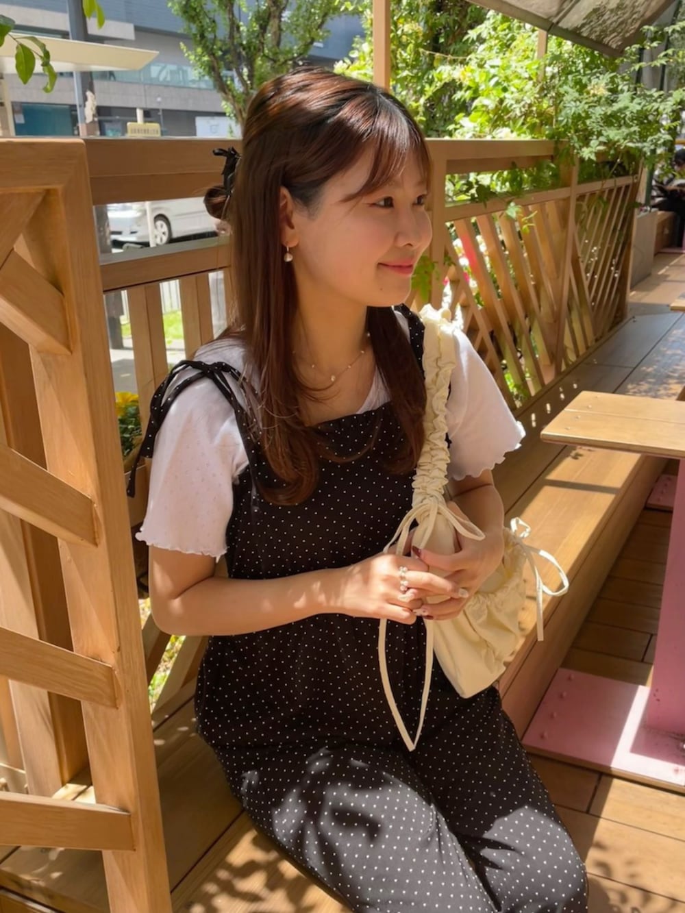 ホワイト系のショルダーバッグ、ブラック系のサロペット/オーバーオール、ホワイト系のTシャツ/カットソーを着用したレディースの春コーディネートの2枚目の写真