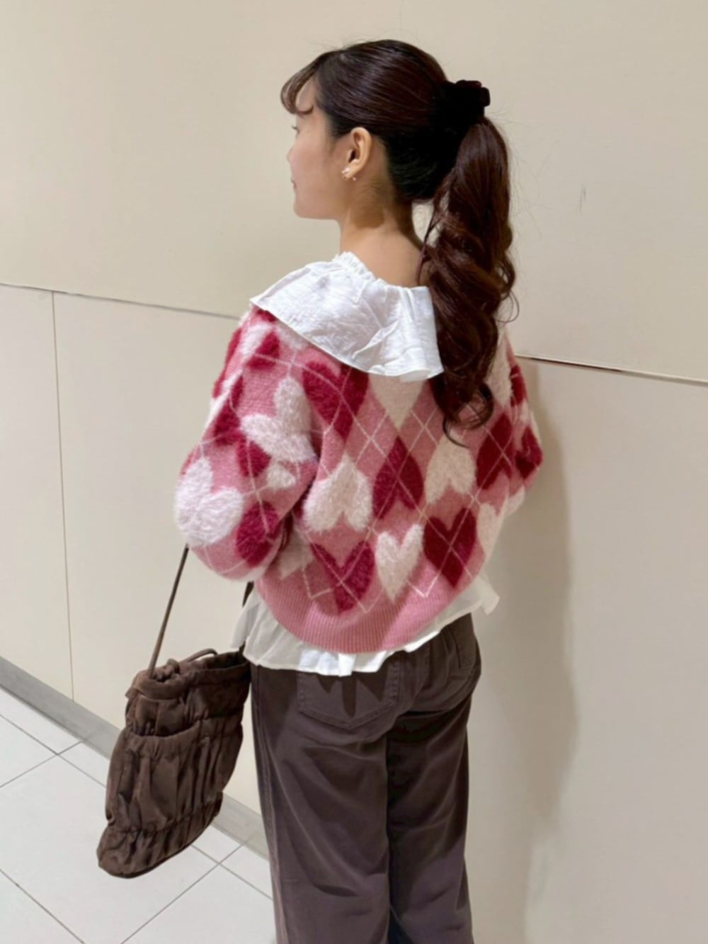 ブラウン系のその他パンツ、ホワイト系のシャツ/ブラウス、レッド系のニット/セーターを着用したレディースの秋コーディネートの3枚目の写真