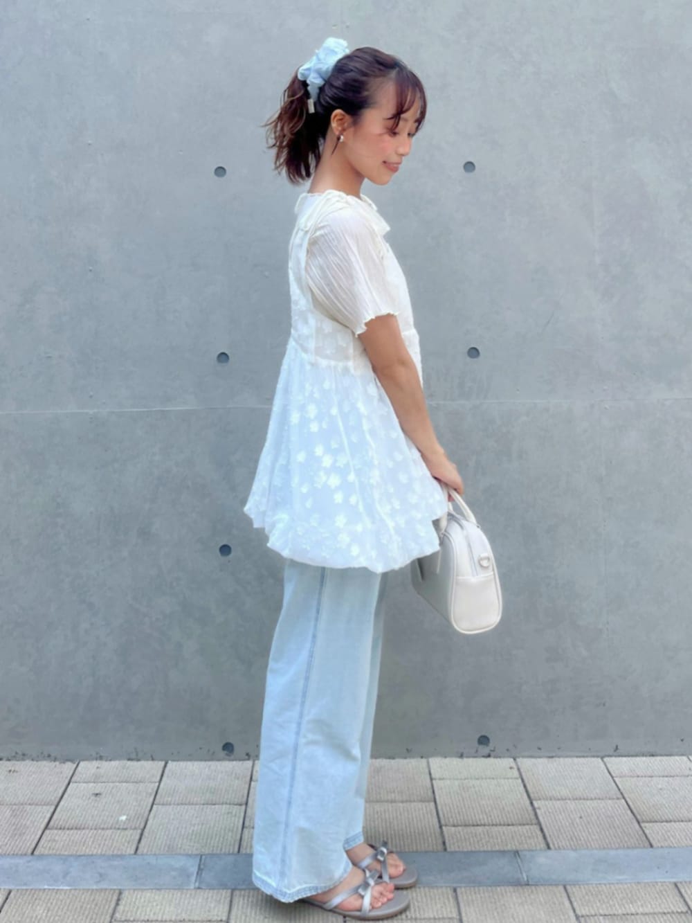 ホワイト系のTシャツ/カットソー、ブルー系のデニムパンツ、ホワイト系のキャミソールを着用したレディースの夏コーディネートの2枚目の写真