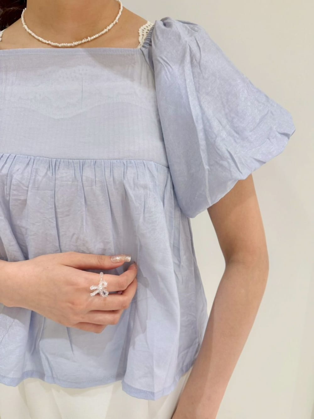 ブラック系のショルダーバッグ、ホワイト系のスカート、ブルー系のシャツ/ブラウスを着用したレディースの春コーディネートの3枚目の写真