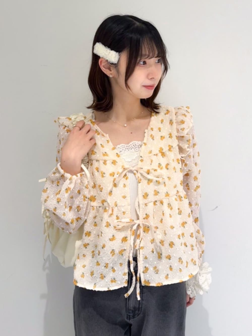 ブラック系のデニムパンツ、ホワイト系のキャミソール、ホワイト系のショルダーバッグを着用したレディースの春コーディネートの2枚目の写真