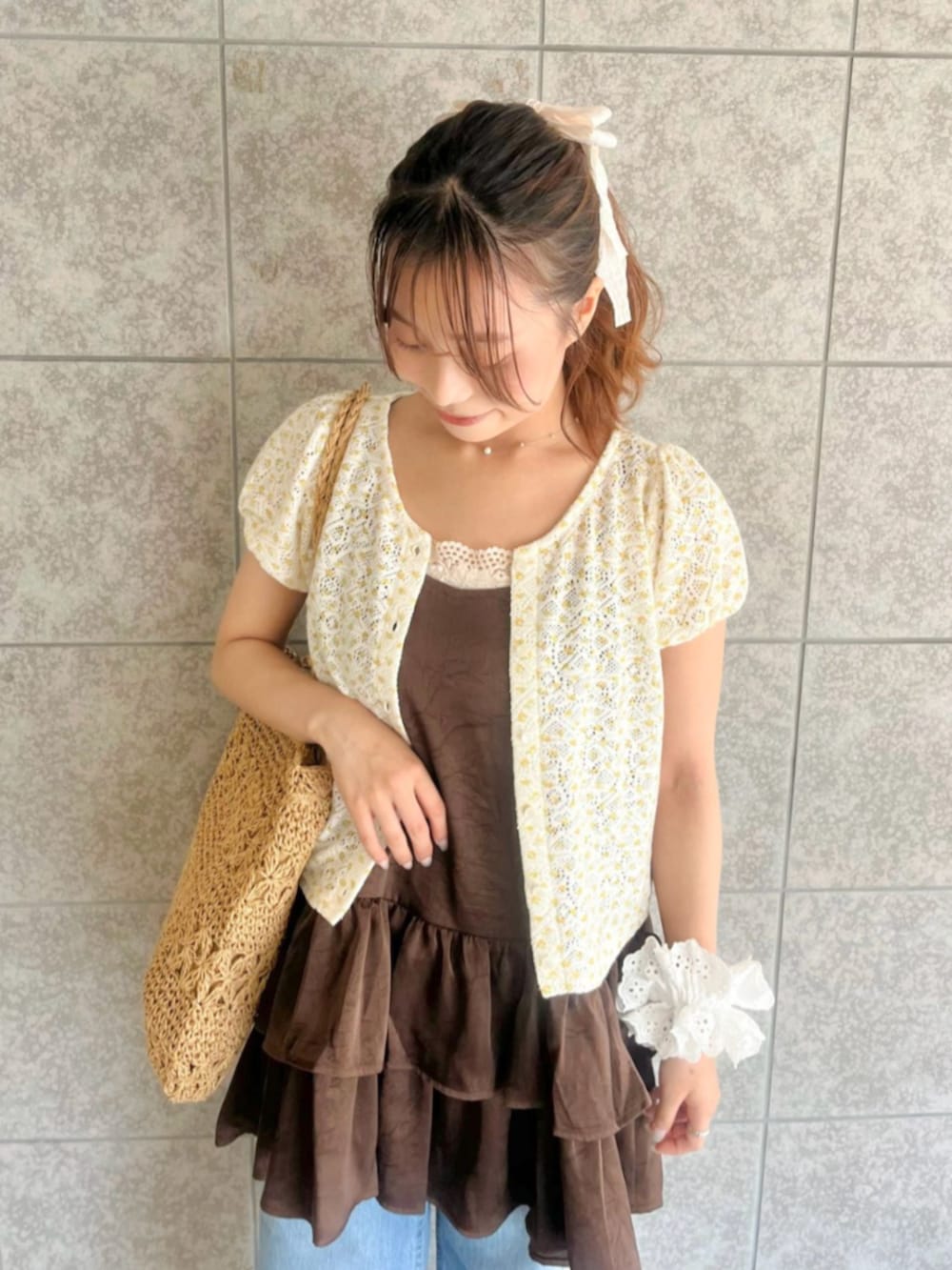 ベージュ系のかごバッグ、ブルー系のデニムパンツ、イエロー系のカーディガン/ボレロを着用したレディースの夏コーディネートの3枚目の写真