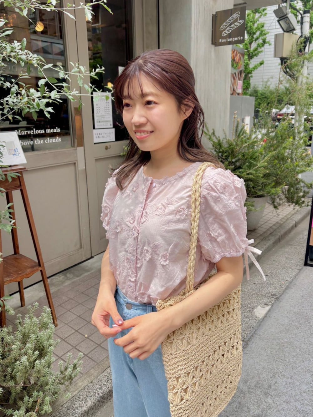 ピンク系のシャツ/ブラウス、ベージュ系のトートバッグ、ブルー系のデニムパンツを着用したレディースの夏コーディネートの2枚目の写真