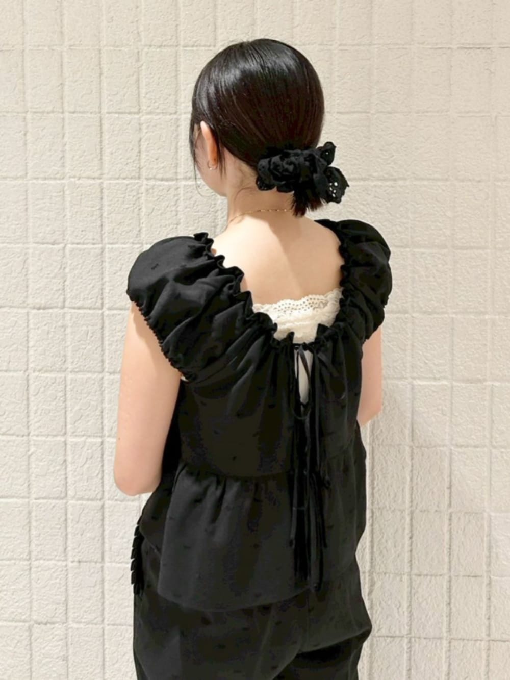 ブラック系のショルダーバッグ、ブラック系のキャミソール、ブラック系のパンツを着用したレディースの秋コーディネートの3枚目の写真