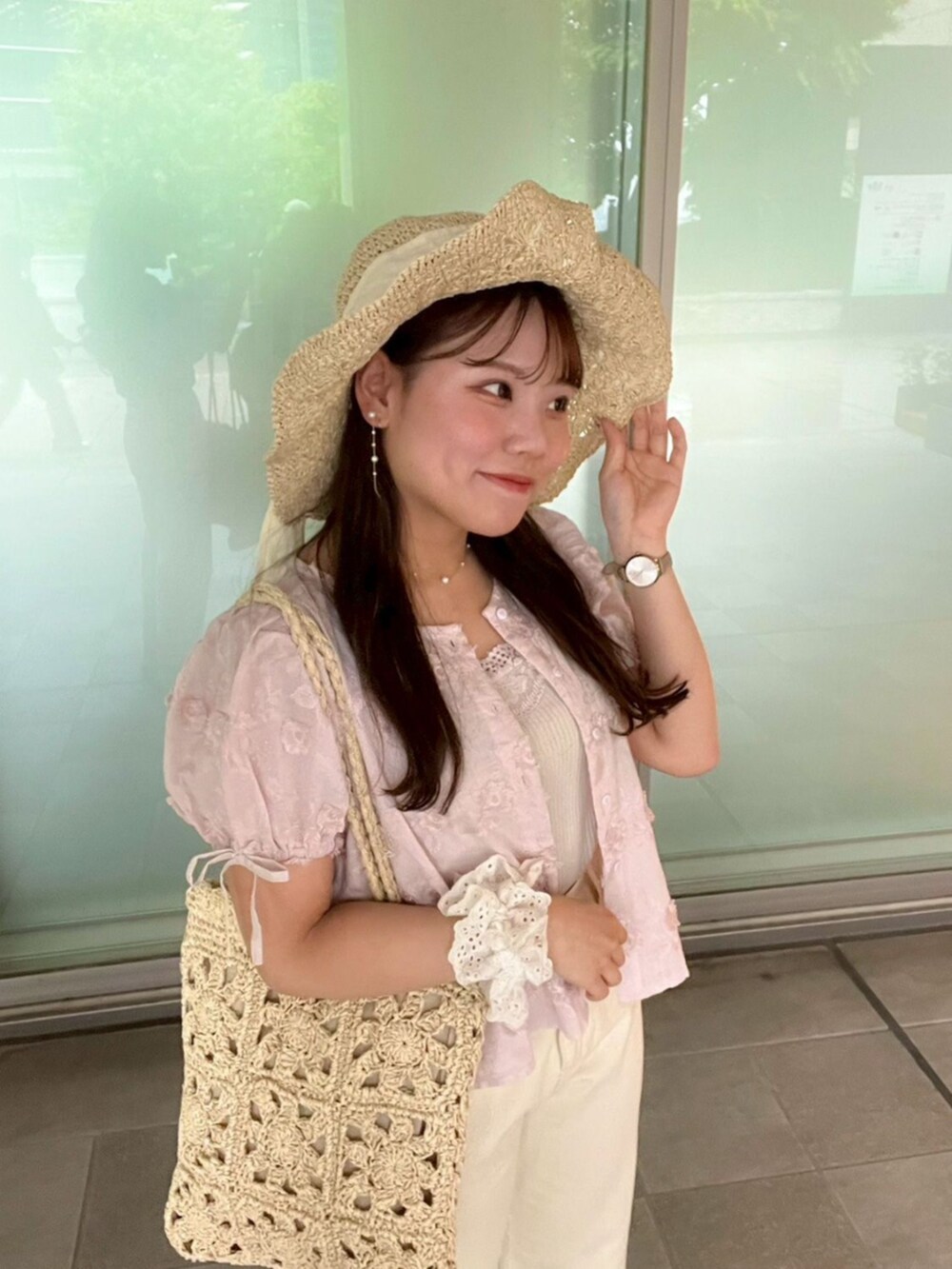 ホワイト系のキャミソール、ホワイト系のデニムパンツ、ベージュ系のかごバッグを着用したレディースの春コーディネートの4枚目の写真