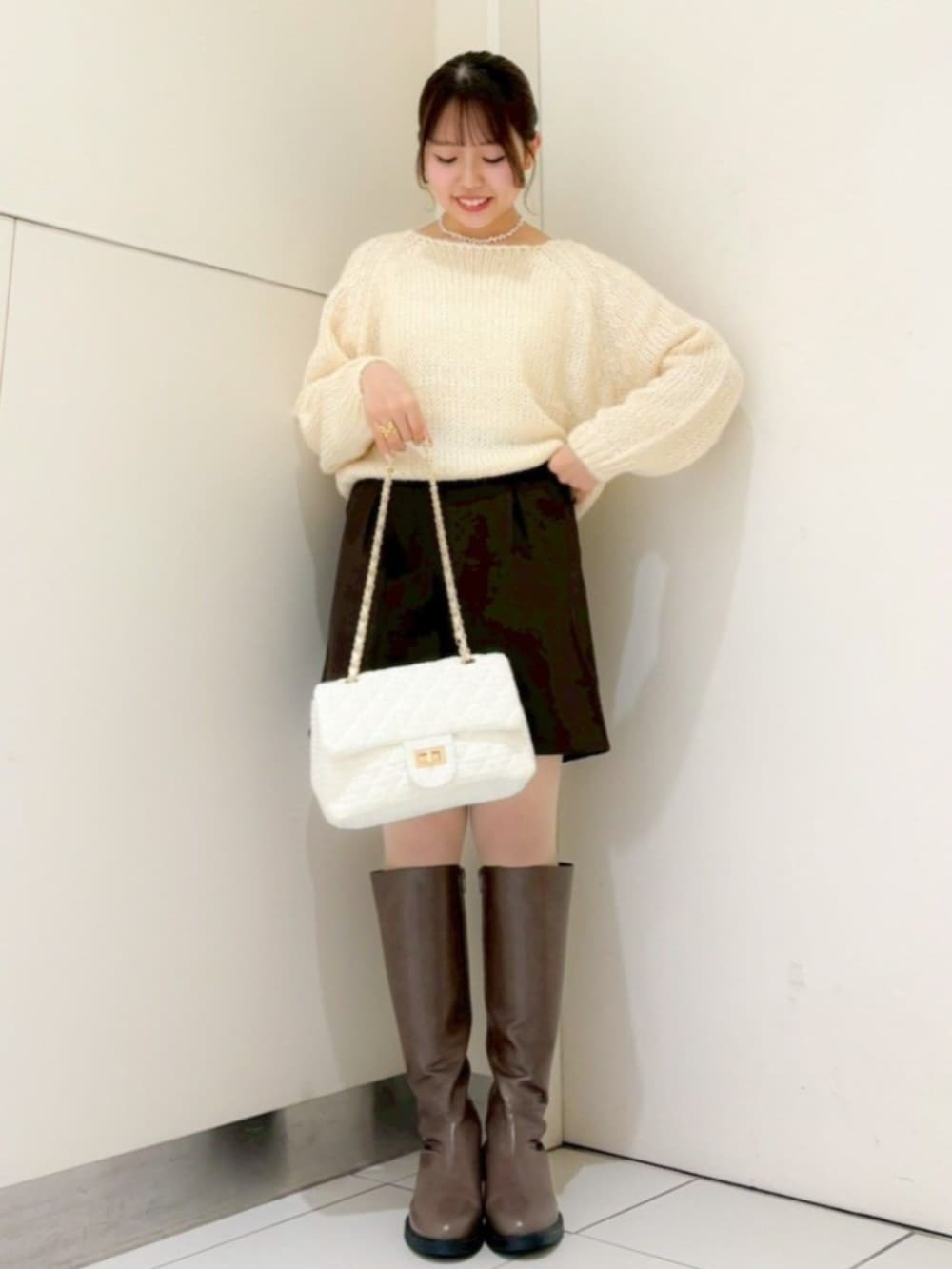 ホワイト系のナイロンジャケット、ホワイト系のショルダーバッグ、ブラウン系のその他パンツを着用したレディースの冬コーディネートの3枚目の写真